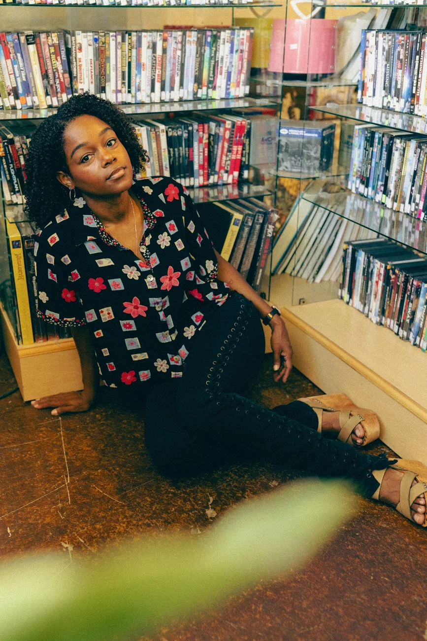 Shante wearing a floral blouse in a record shop